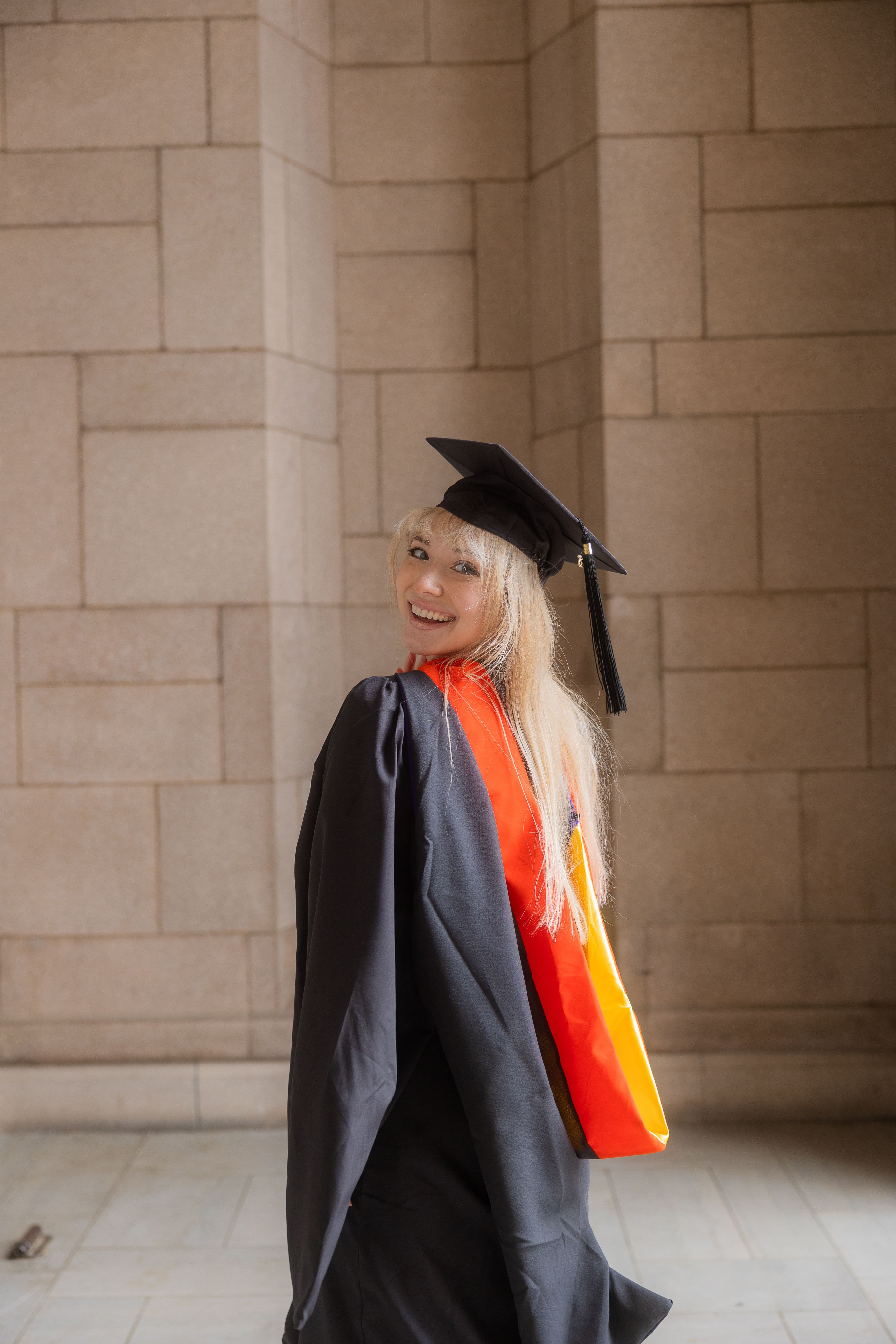 University of Washington graduate posing at the library in her graduation gown